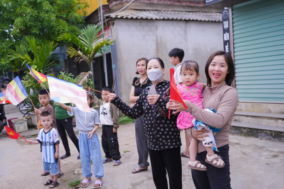 Bà con Nhân dân đứng bên đường, vẫy chào đoàn rước xe hoa. Đó là một tình cảm vô cùng quý báu