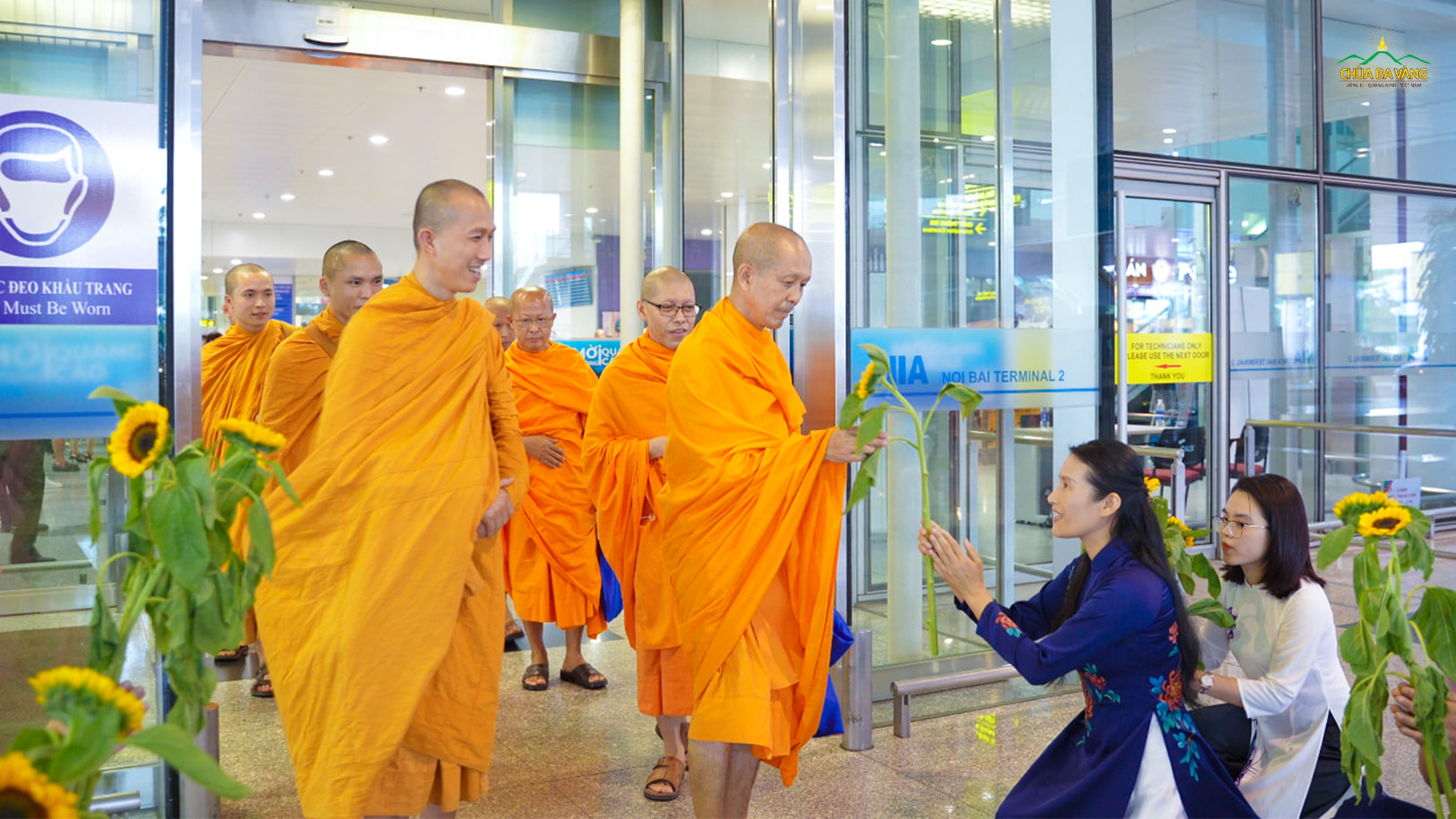 Phật tử cung kính dâng hoa cúng dường chư Tăng chùa Dhammakaya (Thái Lan) tại sân bay Nội Bài