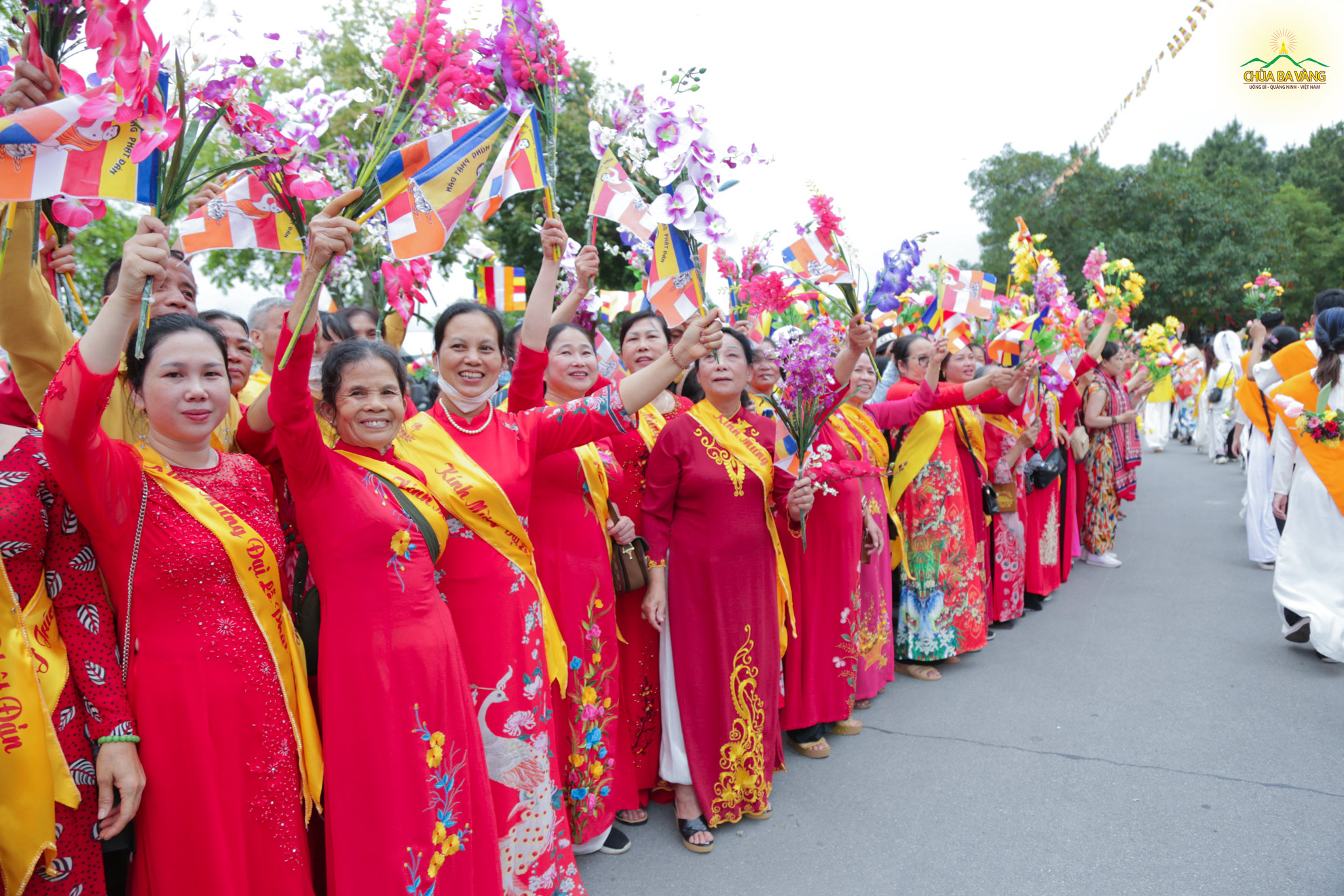 Các Phật tử đứng bên đường vẫy cờ hoa đón chào đoàn diễu hành