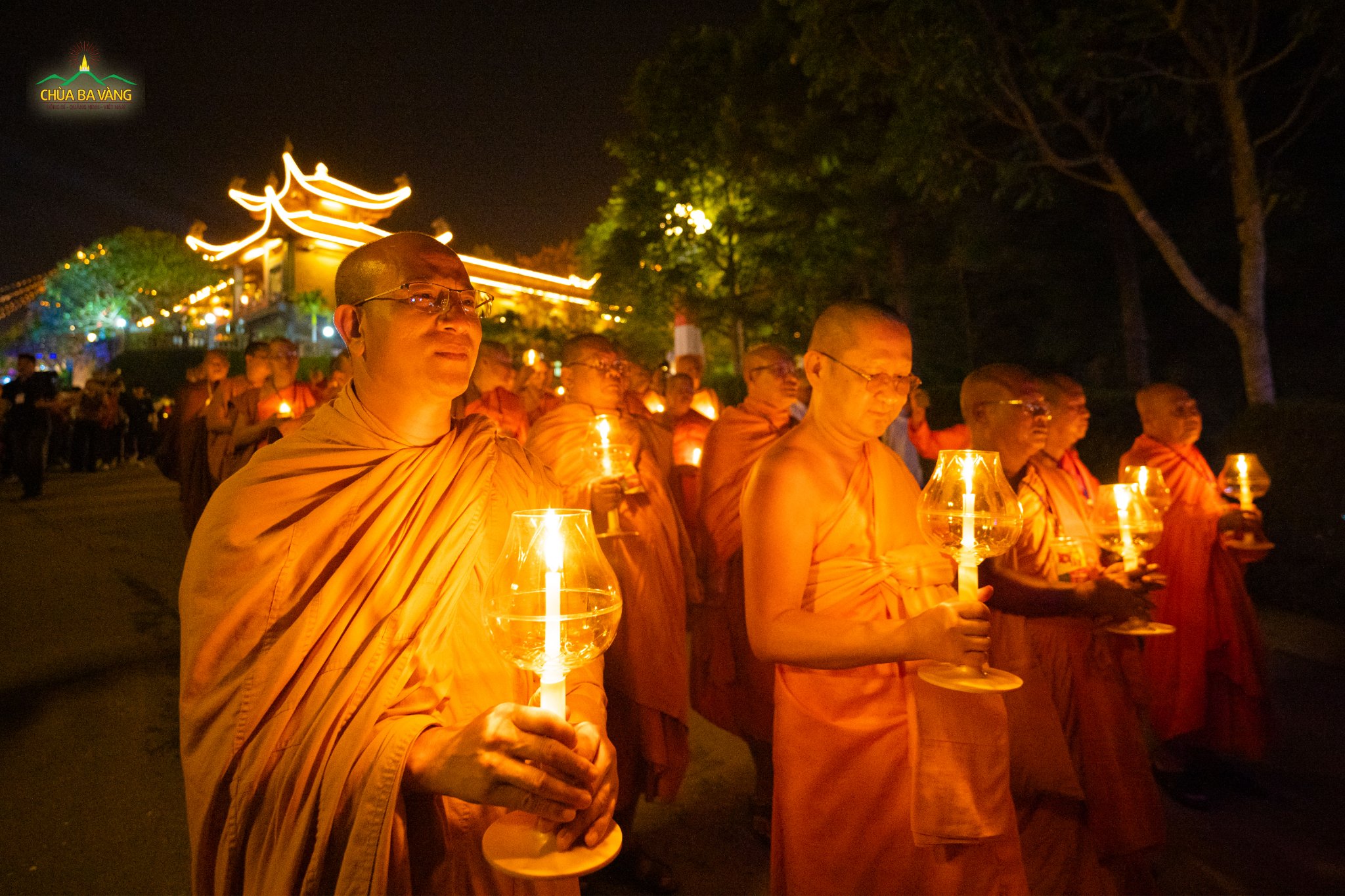 Sư Phụ cùng chư Tôn đức Tăng tại một số quốc gia trên thế giới cầm trên tay những ngọn đăng tỏa rạng và kinh hành trong khuôn viên chùa Ba Vàng