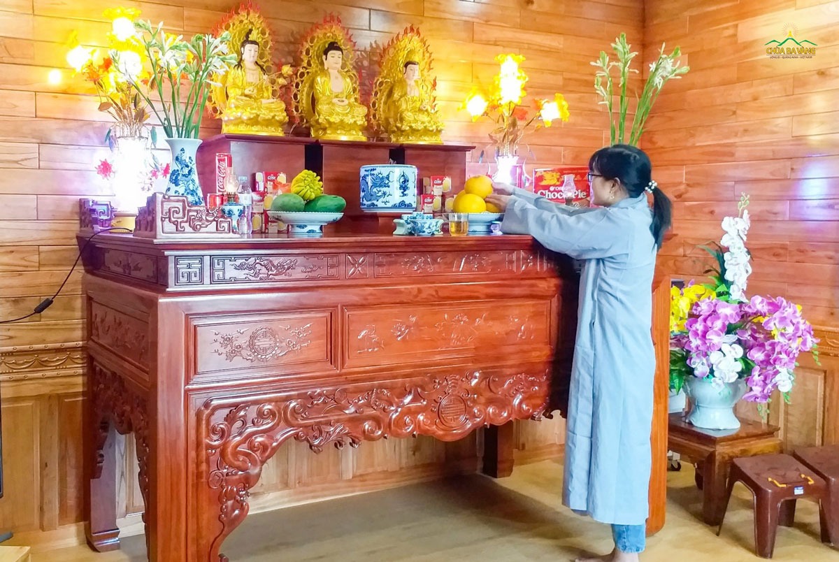 Phật tử bày vật phẩm cúng dường lên bàn thờ Phật