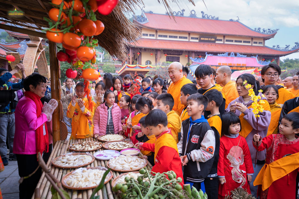 Các bạn nhỏ thích thú khi được Sư Phụ dẫn thăm quan quầy chợ quê với những thức quà truyền thống của dân tộc