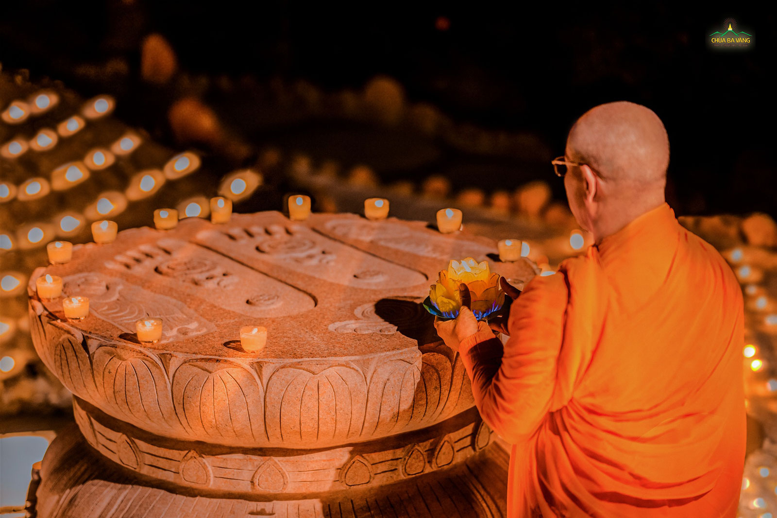 Sư Phụ dâng đăng cúng dường Đức Phật tại khối đá khắc bàn chân Phật