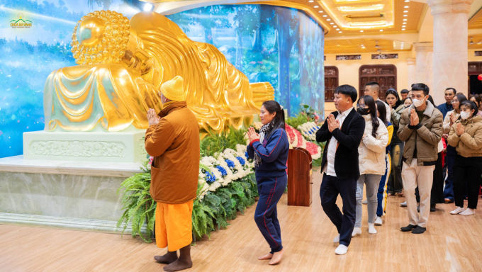 Sư Phụ hướng dẫn du khách đi nhiễu quanh tôn tượng Đức Phật nhập Niết bàn